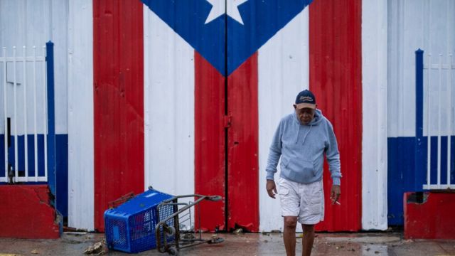 Portret mężczyzny przed flagą Puerto Rico.