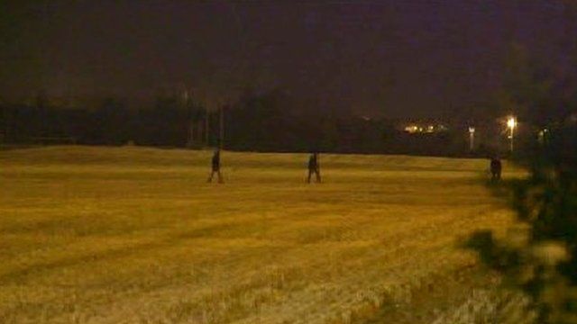 Migrants cross fields behind the village of Frethun, Calais