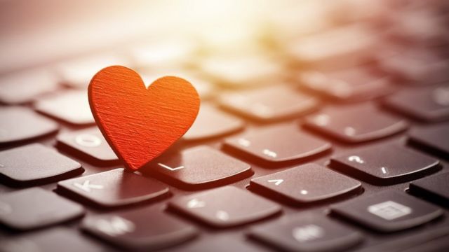 Concept image: a red heart on a computer keyboard.