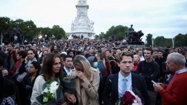 Crowds gather outside the gates of Buckingham Palace in London