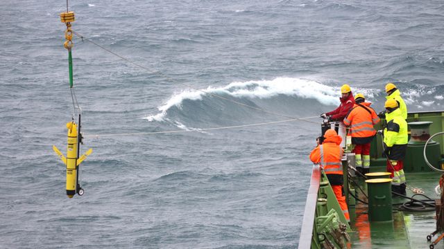 Marinheiros colocam um robô em funcionamento no mar