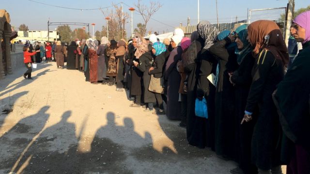 ダマスカス近郊のムアダミヤで支援物資を受け取るため列に並ぶ人々