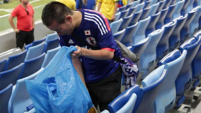 Torcedor do Japão usa saco para recolher o lixo deixado após uma partida do país na Copa da Rússia