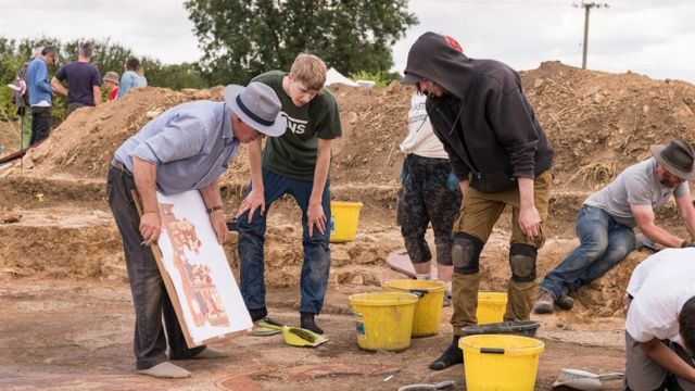 Pessoas na escavação do achado arqueológico