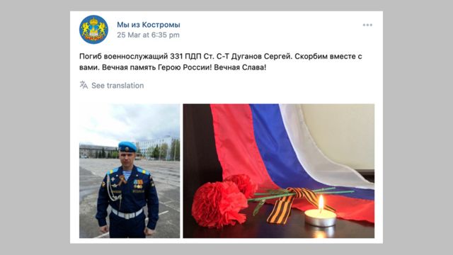 a picture of Sergei Duganov in uniform, a burning candle and a flag