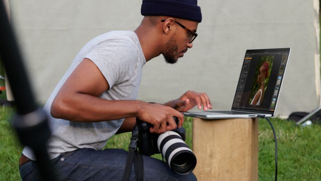 MacBook kullanan bir fotoğrafçı