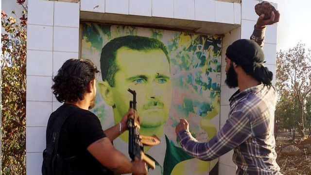 مقاتلو المعارضة السورية يدمرون صورة للأسد (صورة أرشيفية)