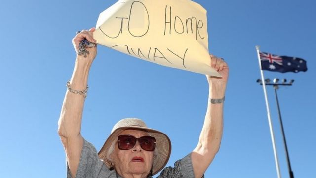 Una mujer con una pancarta en el puerto de Fremantlela: "Váyanse".