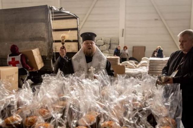 东正教牧师在东正教复活节前在扎波罗热的一个人道主义援助点为复活节蛋糕祝福(photo:BBC)