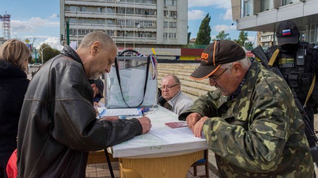 People fill out their ballots face to face at an outdoor polling station in Luhansk, eastern Ukraine