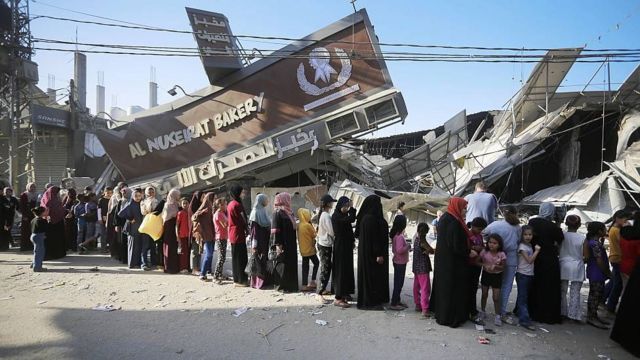 Moradores de Gaza tentam obter pão numa padaria danificada pelos bombardeios e que ainda funciona parcialmente