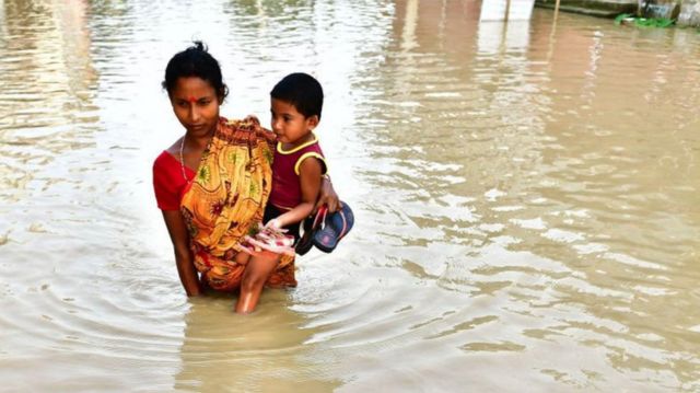 Aldeões indianos abandonam suas casas por causa de enchentes após forte chuva no vilarejo de Baldakhal, nos arredores de Agartala, capital do estado de Tripura, no nordeste da Índia, em novembro de 2008
