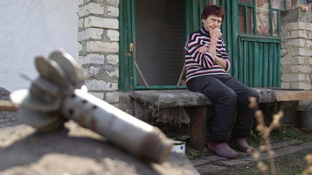 Жінка на зруйнованому подвір'ї, Луганська область