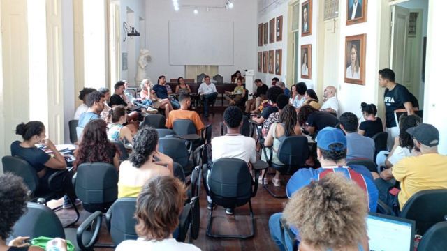 Sala de reuniões cheia de alunos sentados na EBA