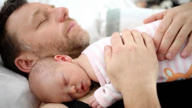 Bebé durmiendo sobre el pecho de su padre.