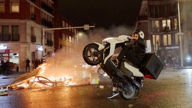 Un homme fait du vélo dans la ville de La Haye en signe de troubles
