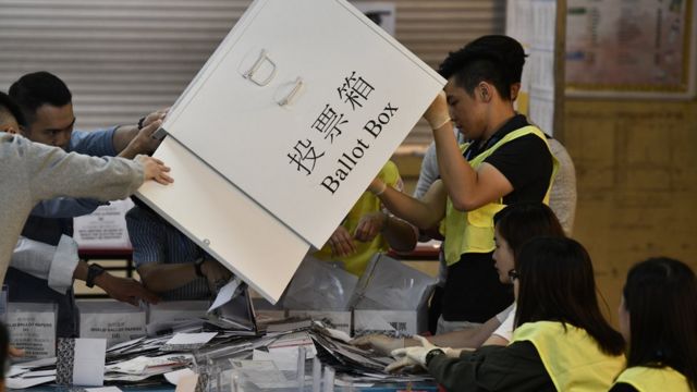 香港屯门一处区议会选举投票站工作人员从投票箱倒出选票准备点票（24/11/2019）