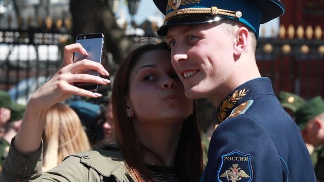 A woman takes a selfie with a Russia soldier