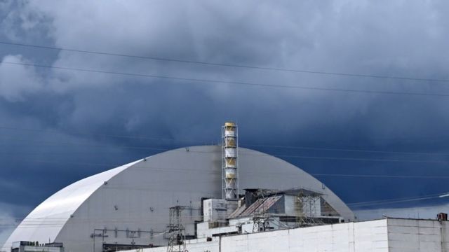 Imagem de parte a usina nuclear desativada de Chernobyl sob um céu carregado de nuvens