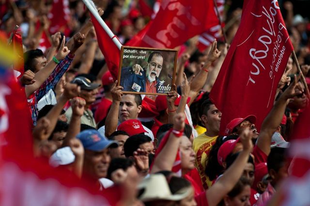 Simpatizantes del FMLN sosteniendo una imagen del líder histórico Jorge Schafik Handal, asisten a una celebración popular organizada por el partido Frente Farabundo Martí para la Liberación Nacional (FMLN) en el centro de San Salvador, El Salvador, el 1 de junio de 2014.
