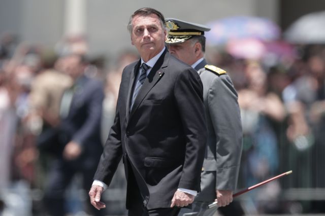 Bolsonaro caminha ao lado de um militar