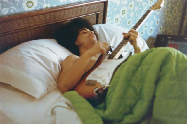 Prince toca guitarra na cama de sua nova casa na France Avenue, em abril de 1978