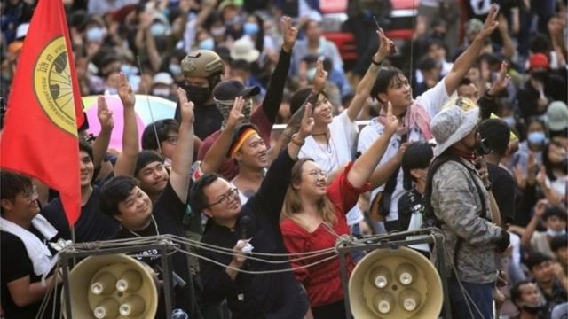 Vocalist protests in a car lifted with three fingers.