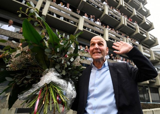 The co-winner of the 2021 Nobel Prize in Chemistry, Germany's Benjamin List, cheers with a bouquet of flowers and is applauded by colleagues at the Max Planck Institute in Muehlheim, Germany, on 6 October 2021