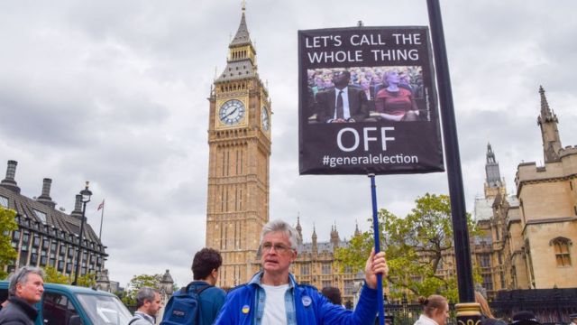 Un hombre sujeta una pancarta pidiendo elecciones generales en Reino Unido