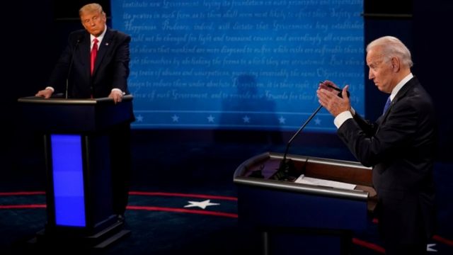 Trump observa Biden discursando em debate