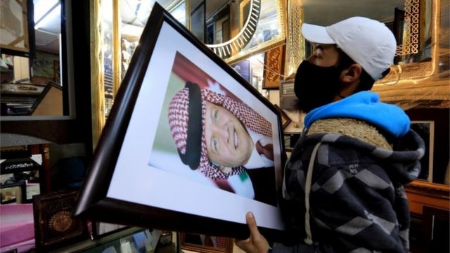 A frame maker in a frame shop displays pictures of King Abdullah II bin Al-Hussein king of Jordan, in Amman, Jordan, 4 April