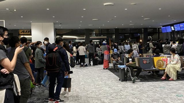 Những người khởi hành từ Los Angeles (Mỹ), quá cảnh sân bay Narita (Nhật) về Việt Nam đang làm thủ tục nhận đồ bảo hộ để lên máy bay về Việt Nam (tháng 10-2021)