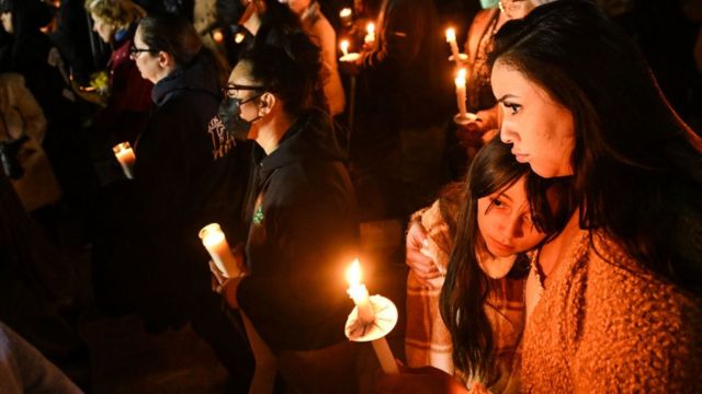 Photo of a woman and a child during a candlelight vigil in California on Tuesday, in the aftermath of three mass shootings in the state