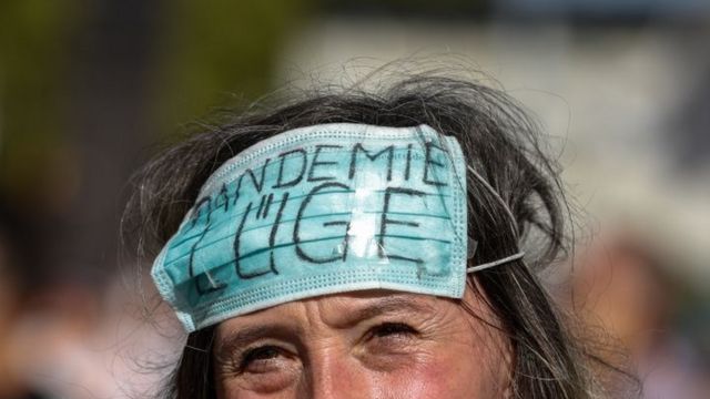 Manifestante en Berlín con una mascarilla en la frente en la que se lee: "Mentira de la pandemia".