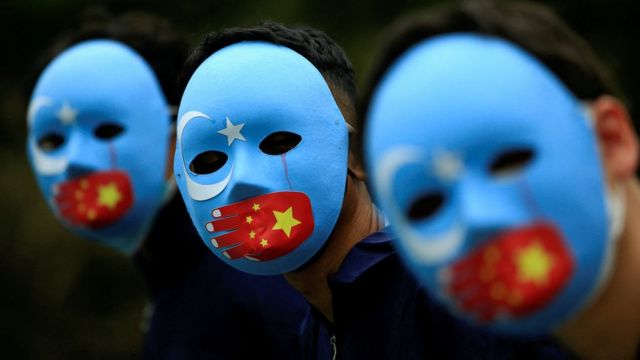 穆斯林戴着有星月标志和中国国旗的面罩举行抗议。