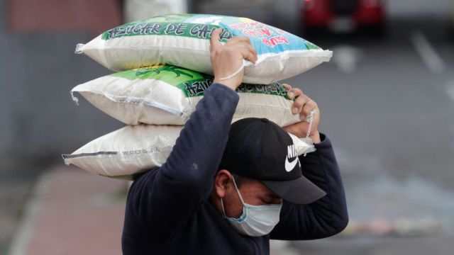 Trabajador cargando un saco en Quito