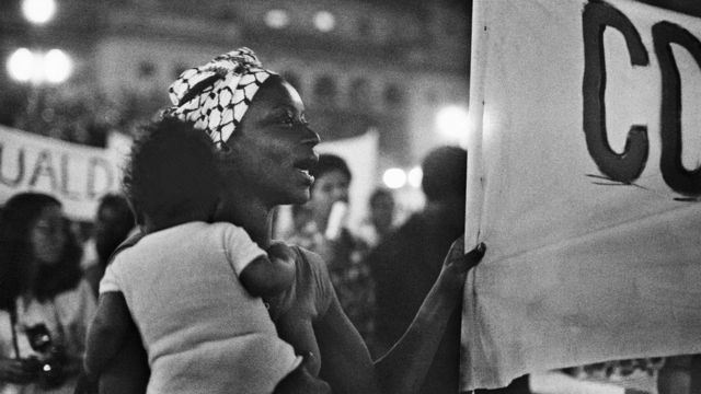 Fátima Ferreira, militante fundadora do MNU, com o filho Samoury nos braços, durante Caminhada por Zumbi no centro de São Paulo, no 20 de novembro de 1979