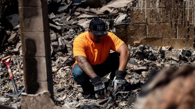 A man sits in the rubble of what once was his bedroom destroyed by a wild fire in Lahaina, Hawaii, USA, 11 August 2023.