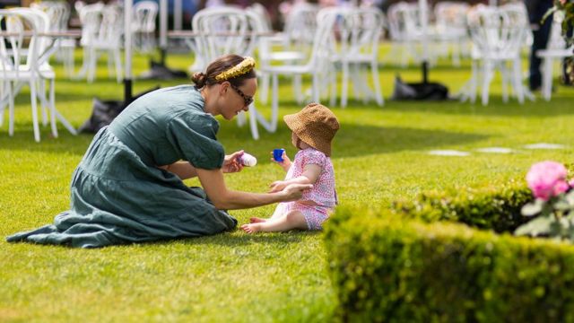 Mulher aplica protetor solar em criança na Flemington Racecourse em Melbourne, na Austrália