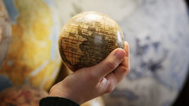 Hombre con un globo terráqueo en la mano