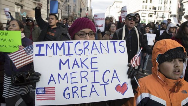 Protestocular Trump'ın seçim kampanyası sloganına atıfla 'Göçmenler Amerika'yı yüceltiyor' yazılı pankartlar taşıdı