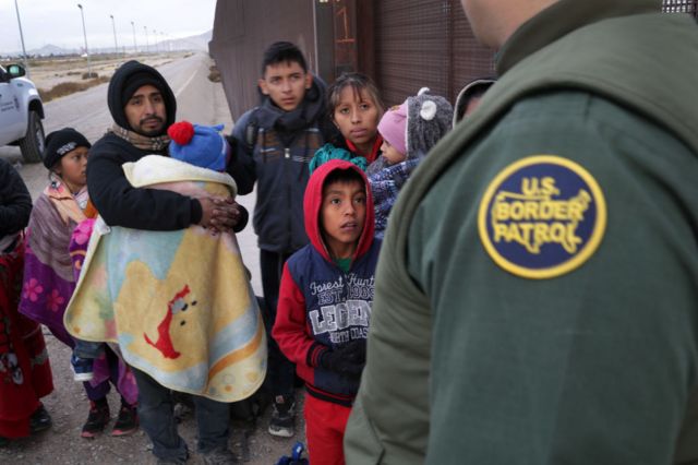 Un agente de la patrulla fronteriza con unos migrantes