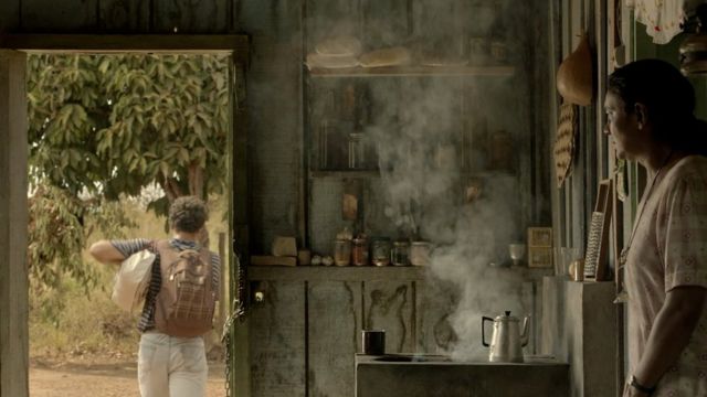 Cena do filme: dentro de casa, uma mulher olha para um jovem que sai de casa com uma mochila