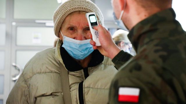 Польский военный проверяет температуру