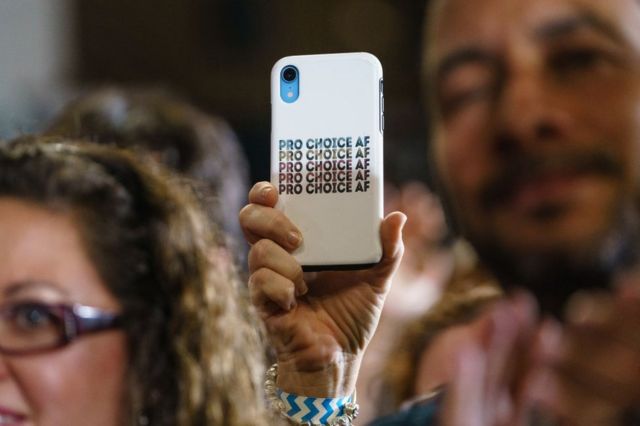 An attendee at a campaign event for Georgia Democrats on October 28, 2022 in College Park, Georgia, with a cell phone with an abortion case.