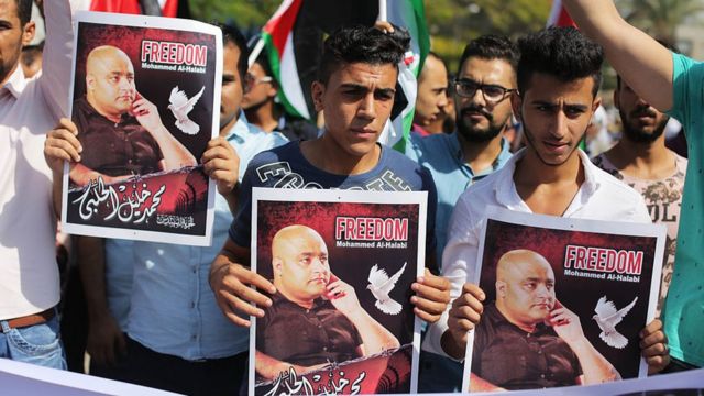 متظاهرون فلسطينيون يحملون صور محمد الحلبي، خلال مسيرة تضامنية أمام مكتب منسق الأمم المتحدة الخاص في غزة عام 2016