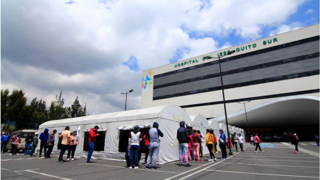 Una fila de personas esperando para ser testeados por covid o para ser atendidos afuera de un hospital en Quito, Ecuador.