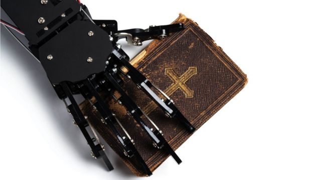 روبوت يضع يده على إنجيل