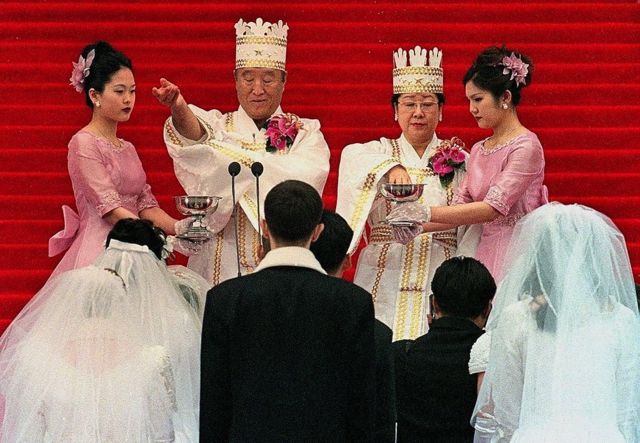 SEOUL, SOUTH KOREA - FEBRUARY 13: Sun Myung Moon (2nd L), founder of the Unification Church, and his wife (2nd R) bless the brides and the grooms in a mass wedding ceremony at Chamsil Olympic Stadium in Seoul 13 February 2000. Unification Church founder Moon married some 60,000 of his believers, many renewing their vows. AFP PHOTO (Photo credit should read PARK MEE-HYANG/AFP via Getty Images)