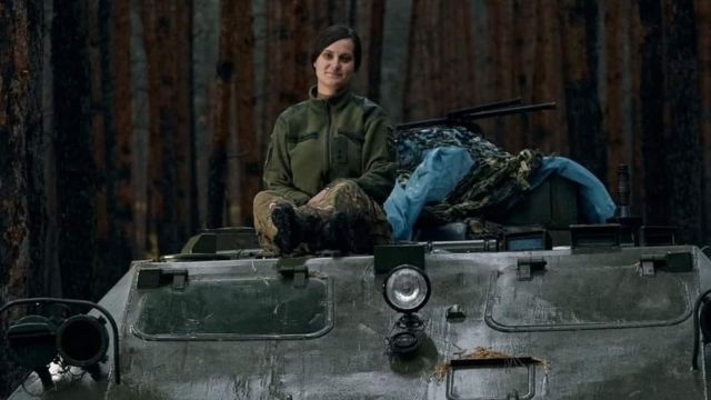 Soldada sentata sobre o teto de um tanque